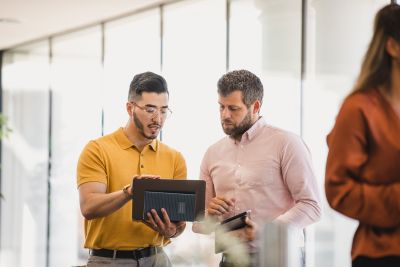 iStock Eine Person zeigt etwas auf einem Tablet einer andere Person.